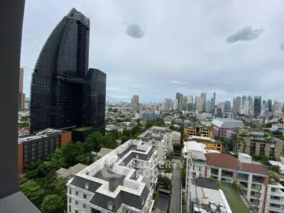 Stunning cityscape view from high-rise balcony showcasing modern architecture and lush greenery.