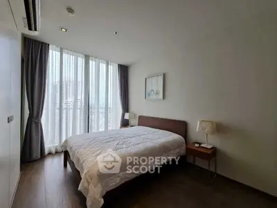 Modern bedroom with large window and stylish decor in urban apartment