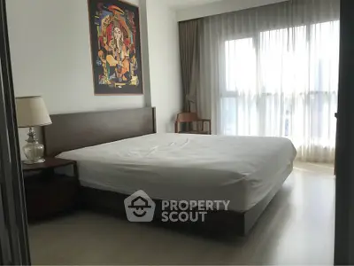 Spacious bedroom with modern decor and large windows for natural light