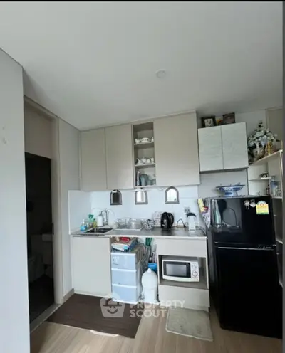 Compact kitchen with modern appliances and sleek cabinetry in cozy apartment