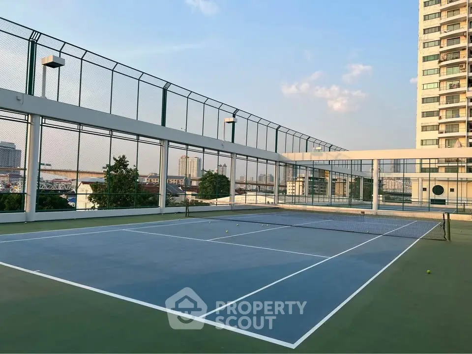 Stunning rooftop tennis court with city views in modern residential building.