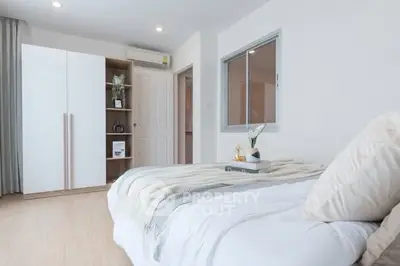 Modern bedroom with cozy decor and ample natural light