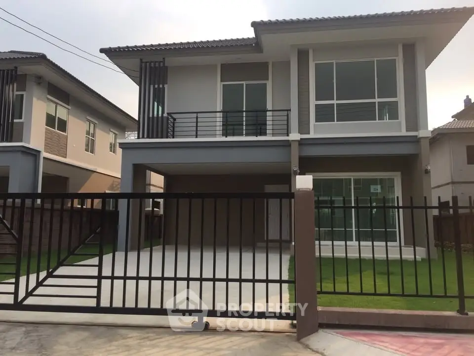 Modern two-story house with gated driveway and large windows