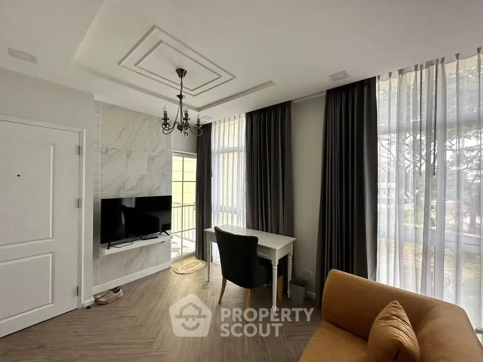 Modern living room with elegant decor, large windows, and stylish furniture in a cozy apartment.