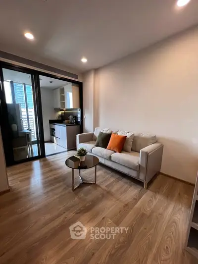 Modern living room with cozy sofa and open kitchen in a high-rise apartment