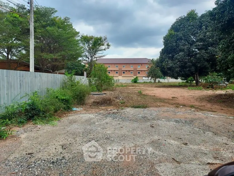 Vacant land with potential for development, surrounded by greenery and residential buildings.