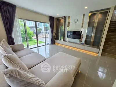 Spacious modern living room with large windows and elegant decor, perfect for relaxation and entertainment.