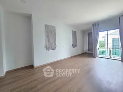 Spacious empty room with large windows and balcony access, perfect for customization.