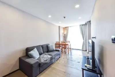 Modern living room with cozy sofa and dining area, featuring natural light and stylish decor.