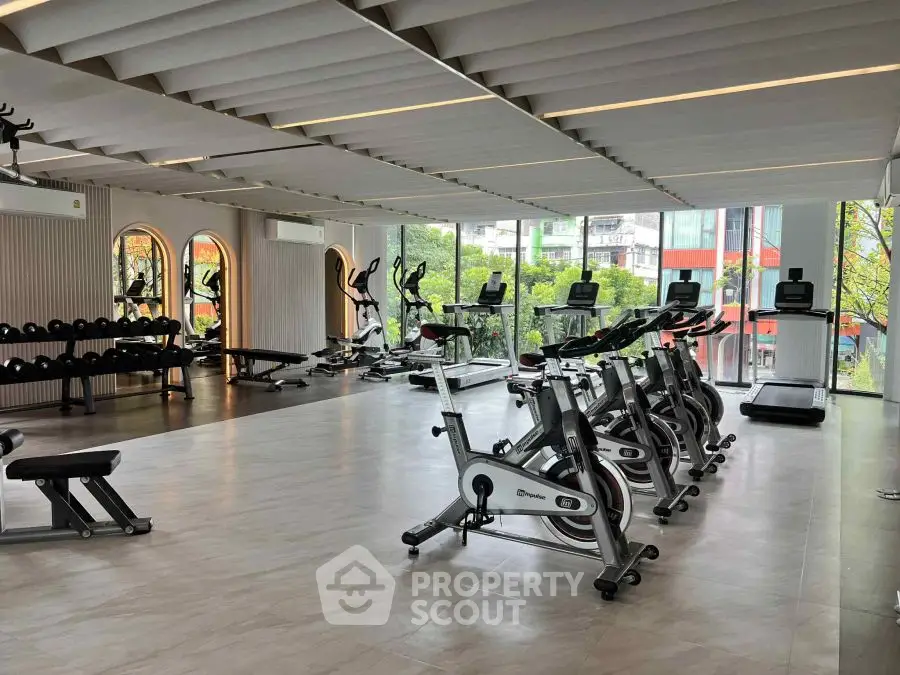 Spacious modern gym with state-of-the-art equipment and large windows offering a scenic view.