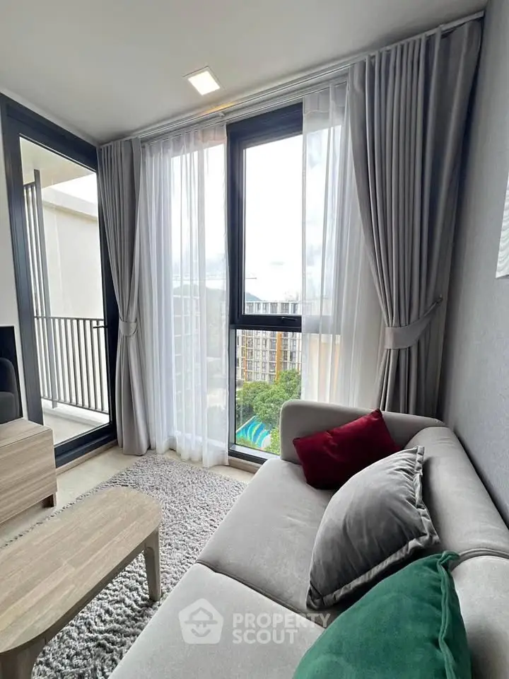 Modern living room with large windows and balcony view in a stylish apartment.
