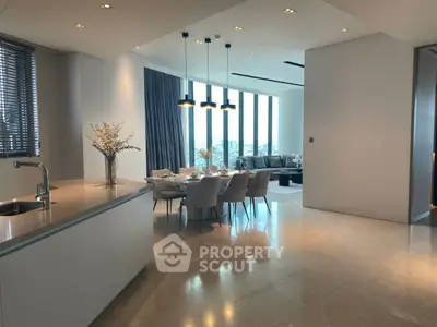 Luxurious open-plan kitchen and dining area with modern decor and panoramic city views.