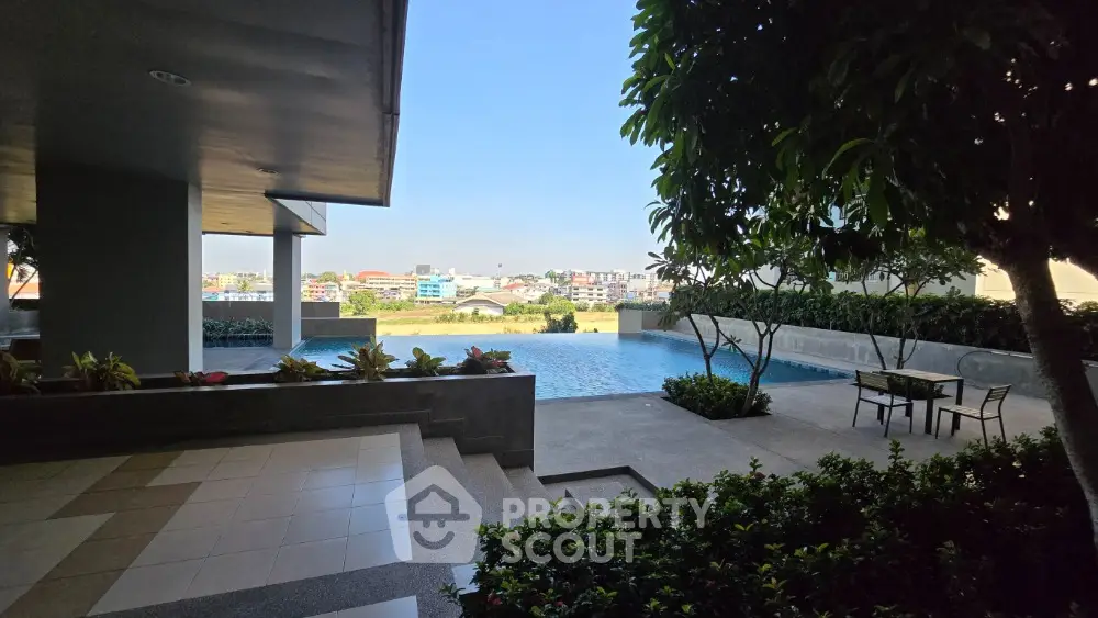 Luxurious poolside view with lush greenery and cityscape in the background
