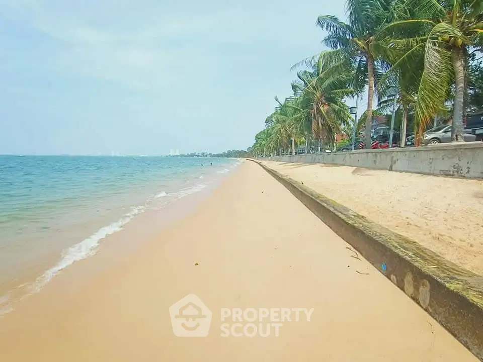 Stunning beachfront view with palm trees and clear blue waters, perfect for coastal living.