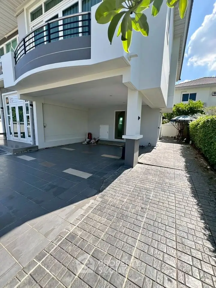 Spacious modern home exterior with covered parking and landscaped pathway.