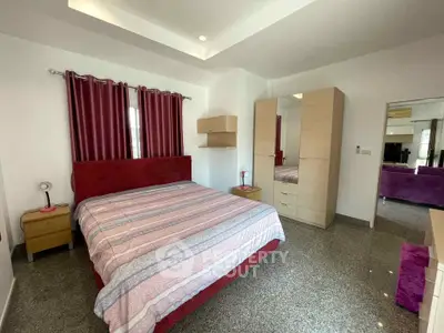Spacious bedroom with modern furnishings and natural light, featuring a comfortable bed and ample storage.