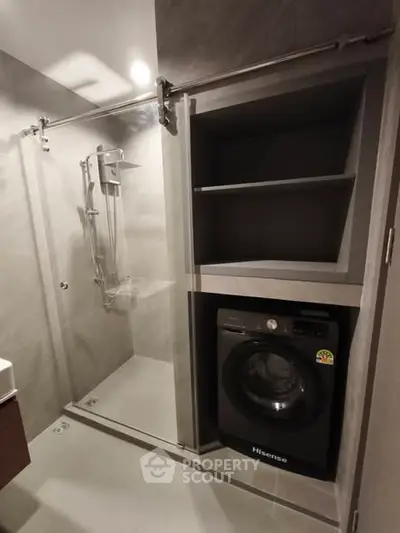 Modern bathroom with sleek shower and built-in washing machine, perfect for compact living spaces.
