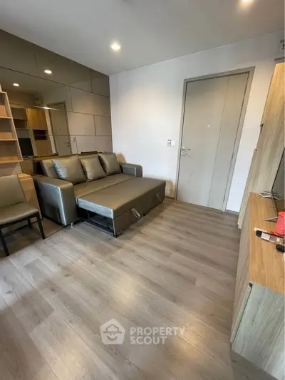 Modern living room with sleek furniture and wooden flooring, perfect for urban living.