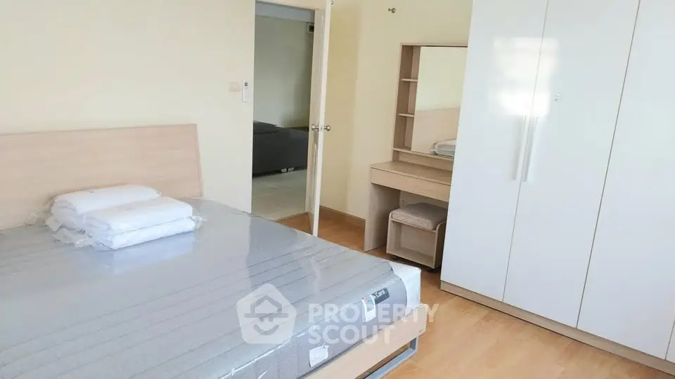 Spacious bedroom with modern furniture and ample storage in a cozy apartment.