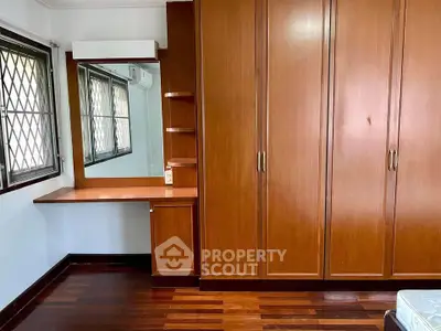 Spacious bedroom with wooden wardrobe and built-in vanity desk