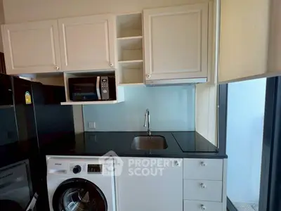 Modern kitchen with sleek appliances and ample storage in a stylish apartment.