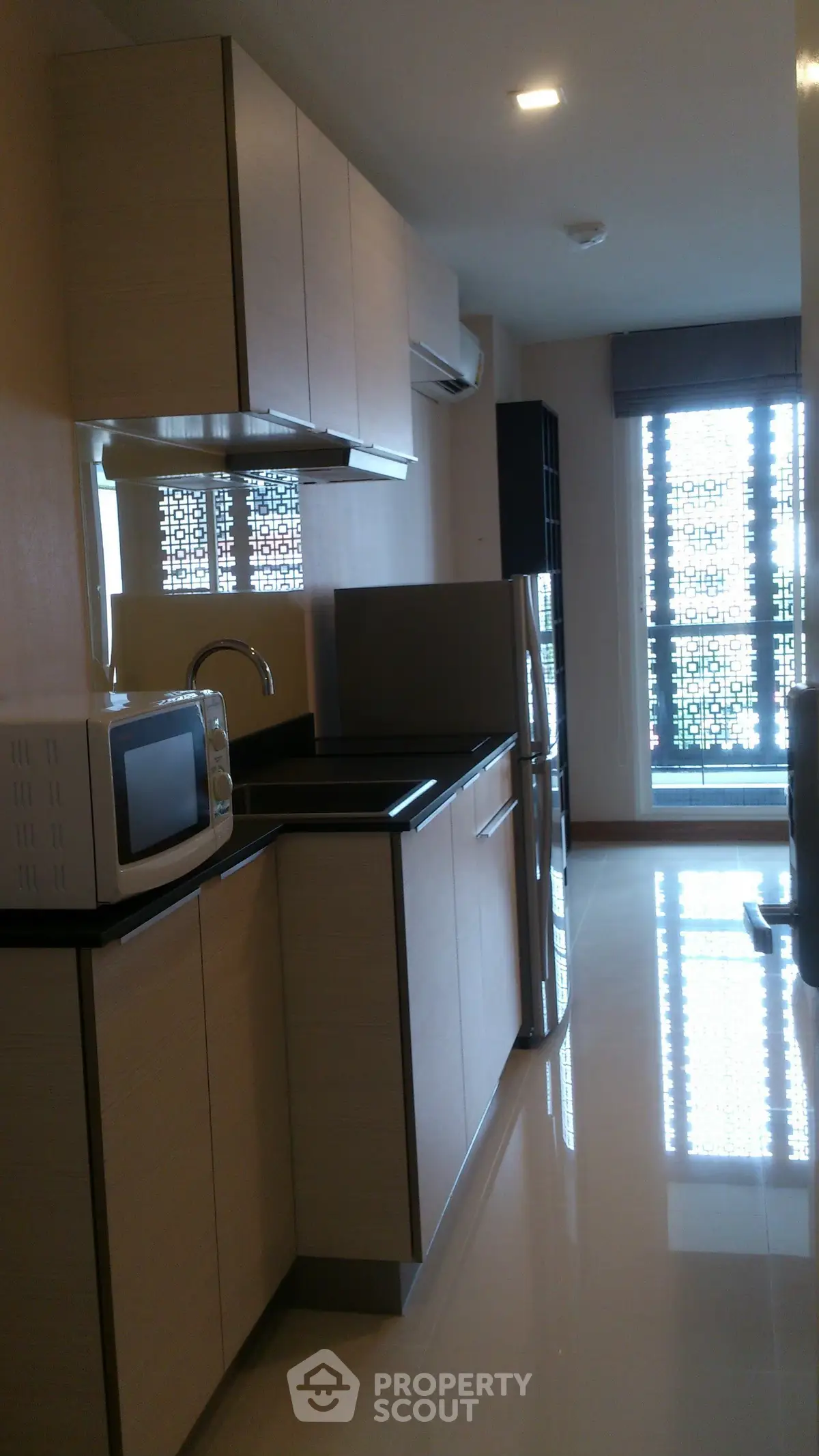 Modern kitchen with sleek cabinets and stainless steel appliances in a bright apartment.