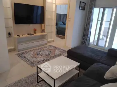 Modern living room with sleek furniture and large TV, perfect for relaxation.