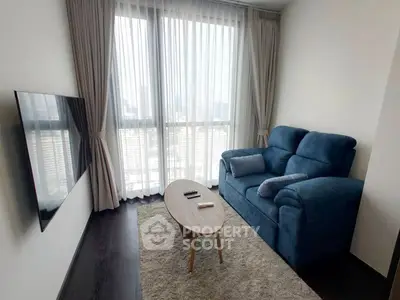 Cozy living room with plush blue sofa and city view from large windows