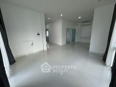 Spacious modern living room with sleek tile flooring and ample natural light