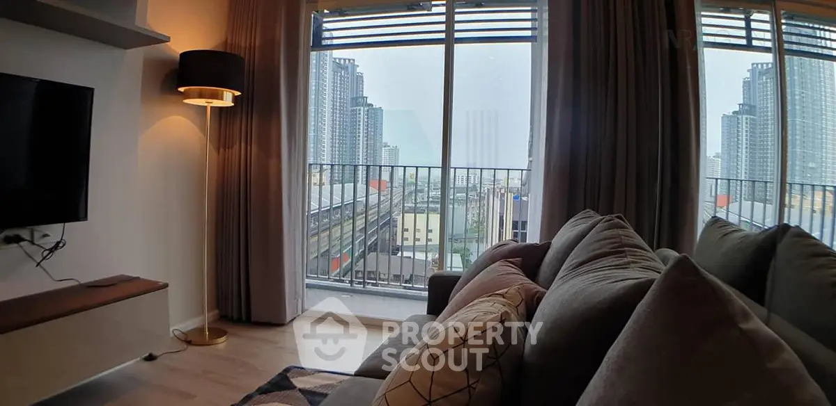 Modern living room with large windows offering stunning city view and cozy seating area.