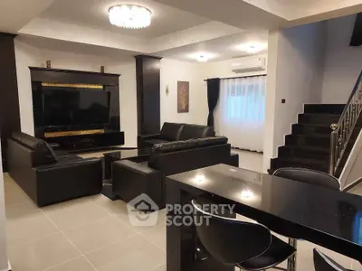 Luxurious modern living room with sleek black leather sofas and elegant decor