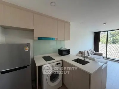 Modern kitchen with washing machine and open layout in bright apartment