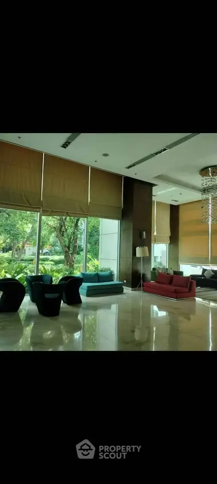 Luxurious lobby with modern seating and large windows overlooking lush greenery.