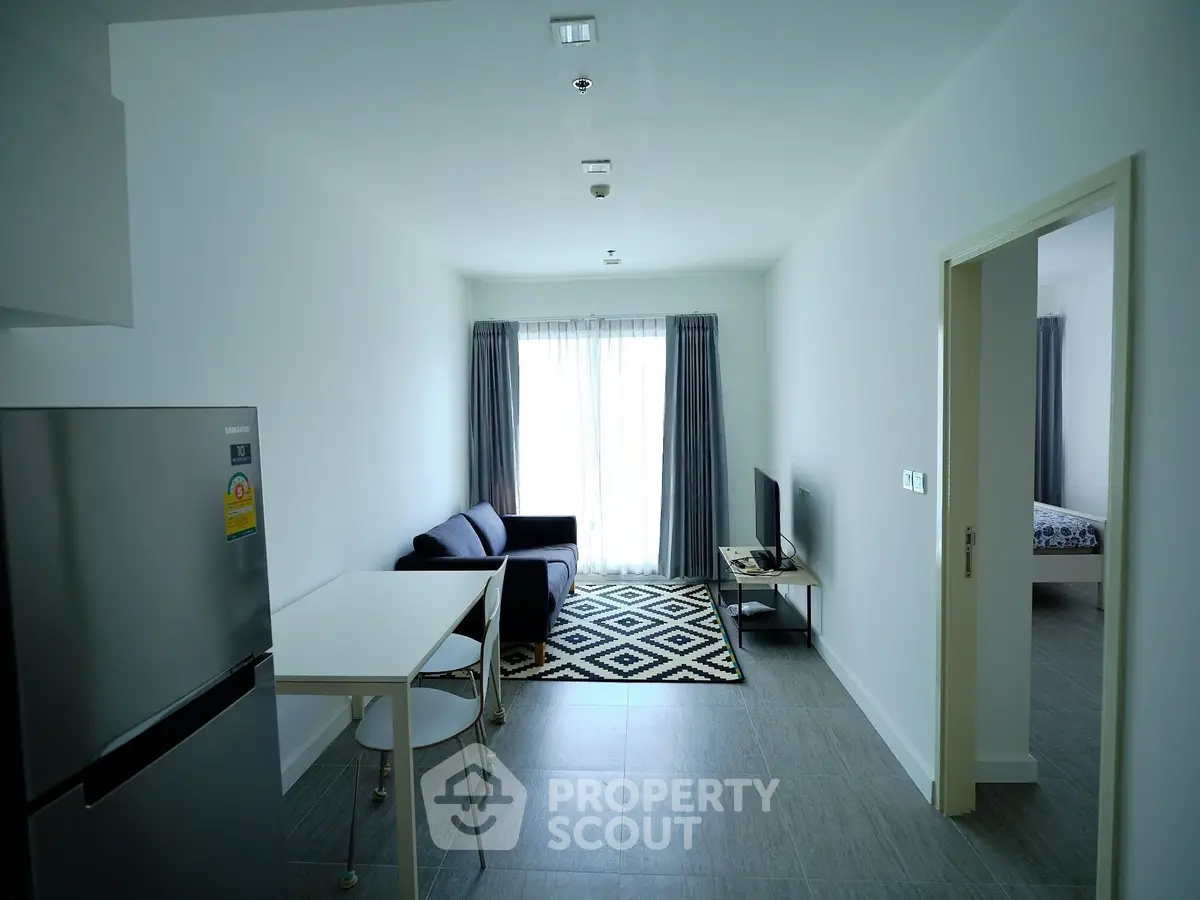 Modern apartment interior with sleek kitchen and cozy living area, featuring stylish decor and natural light.