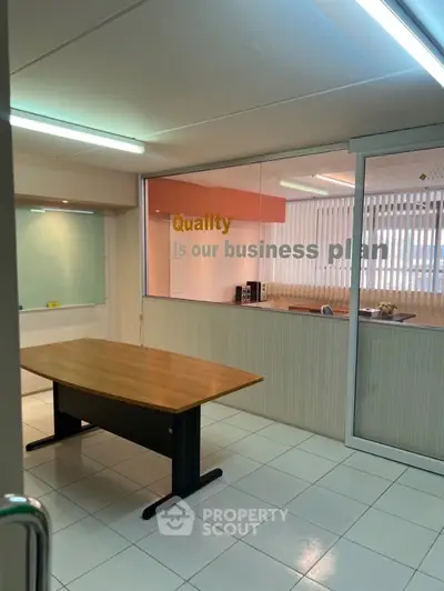 Spacious office meeting room with modern glass partition and motivational quote