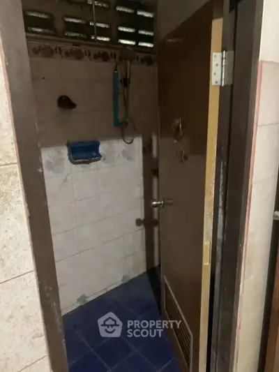 Compact bathroom with tiled walls and blue flooring