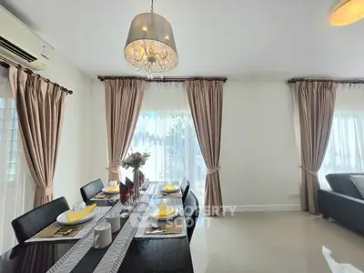 Elegant dining area with chandelier and natural light in modern home