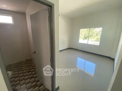 Spacious room with large window and adjacent bathroom, perfect for modern living.