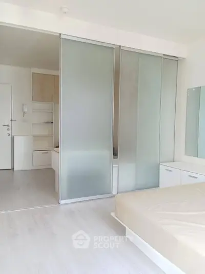 Modern minimalist bedroom with sliding glass doors and neutral decor