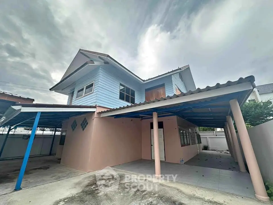 Charming two-story house with covered parking and spacious outdoor area, perfect for family living.