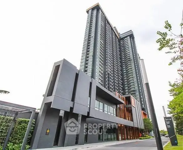 Modern high-rise building with sleek architectural design and lush surroundings.