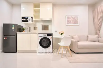 Modern open-layout kitchen and living room with sleek appliances and cozy seating area.