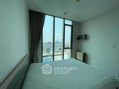 Modern bedroom with large windows offering city view in high-rise apartment