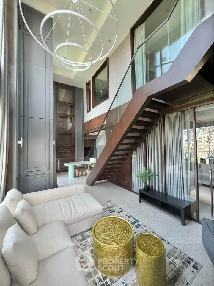 Luxurious modern living room with high ceilings and elegant staircase