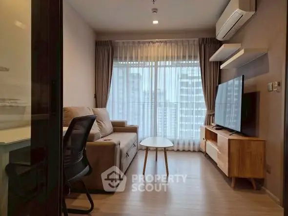 Modern living room with city view, featuring sleek furniture and large windows for natural light.