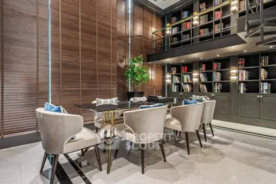 Luxurious dining area with elegant chairs and modern bookshelf in a sophisticated setting.