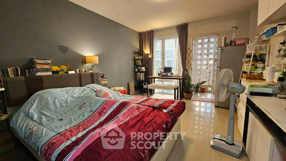 Cozy bedroom with modern decor and natural light, featuring a comfortable bed and functional workspace.