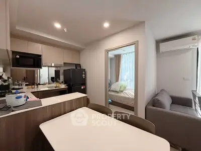 Modern open-layout kitchen and cozy living area with bedroom view