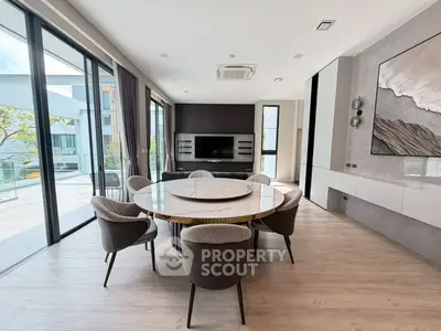 Luxurious modern living room with elegant dining area and large windows offering natural light.