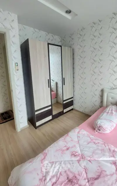 Cozy bedroom with stylish wardrobe and pink bedding in modern apartment